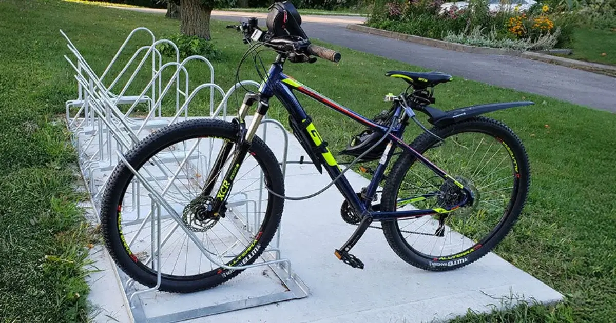 Mountain bike parked in a metal bike rack outdoors.